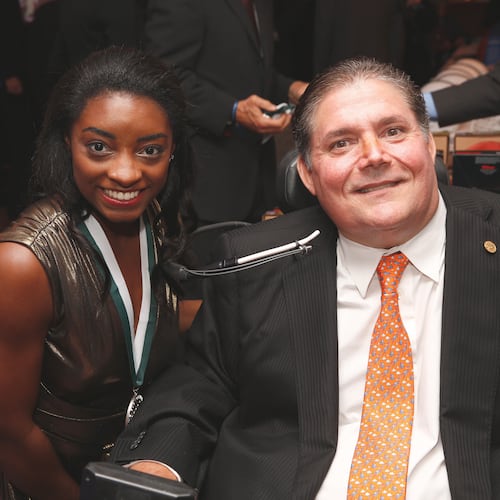 In this photo released by The Buoniconti Fund to Cure Paralysis, Olympic gold medal winning gymnast Simone Biles, left, poses with The Buoniconti Fund to Cure Paralysis President Marc Buoniconti at the 2018 Great Sports Legends Dinner, Sept. 24, 2018, to benefit the fund in New York. (The Buoniconti Fund to Cure Paralysis via AP)