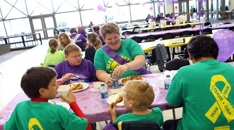 Evan Pina-White (facing on left), 13, from Eureka and his mother Mary White (facing on right) sit with the rest of their family during the Rockwood School District's American Cancer Society Relay for Life survivor's dinner on Friday, June 1, 2012, in Fenton. Pictured from left to right in the foreground are White's other sons Bennett Pina-White, 8, Gabe Pina-White, 6, and her husband Luis Pina. (Johnny Andrews/St. Louis Post-Dispatch/TNS)