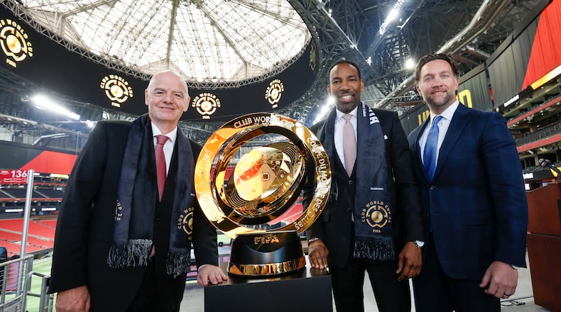 FIFA President Gianni Infantino (left), poses with the Club World Cup trophy, Mayor Andre Dickens, and Arthur M. Blank Sports & Entertainment President Tim Zulawski on Monday in Mercedes-Benz Stadium.