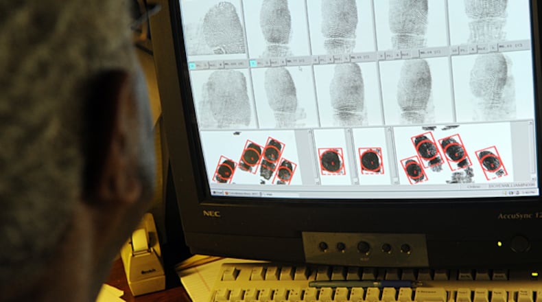 Fingerprint technician William Boyd inspects fingerprints and potential fingerprint matches at the Georgia Crime Information Center, a division of the Georgia Bureau of Investigations, in Decatur Monday, Aug. 15, 2011. The system is usually automated, but it will flag certain prints with anomalies so they can be looked at with a human eye. More employers, both private and public, are using background checks to screen potential job candidates.