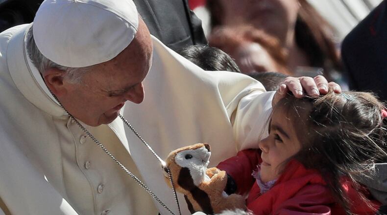 Pope Francis caresses a child during his weekly general audience, in St. Peter’s Square, at the Vatican in 2016. (AP Photo/Alessandra Tarantino)