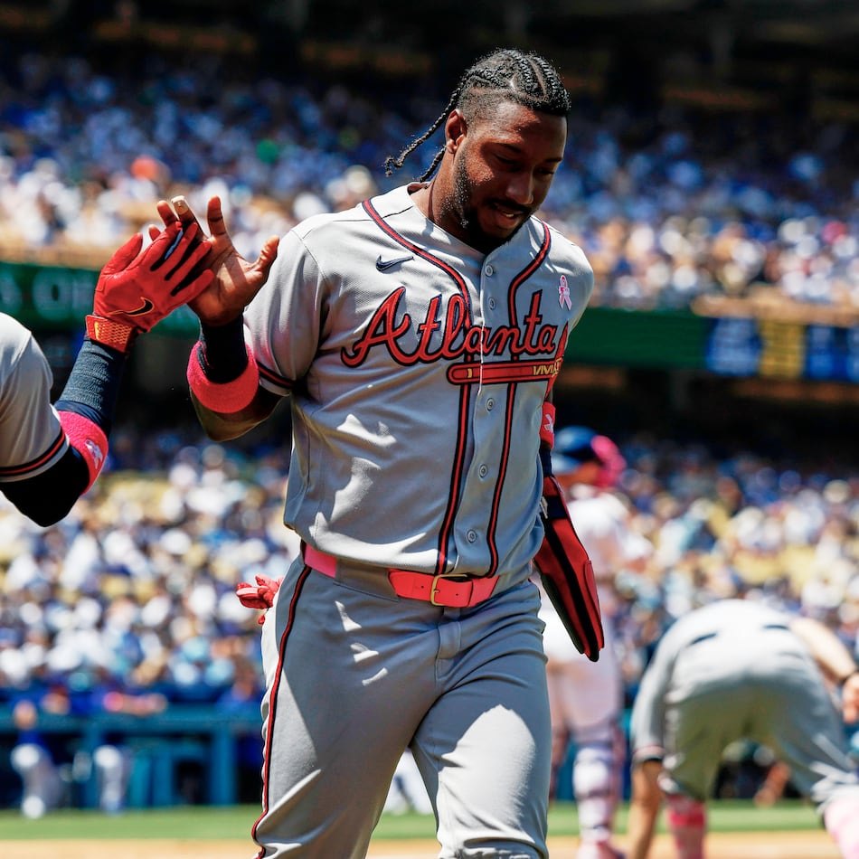Atlanta Braves' Jorge Mateo, right, is greeted by Ozzie Albies (1) on a a two-run double by Atlanta Braves' Mauricio Dubon during the second inning of a baseball game against the Los Angeles Dodgers, Sunday, May 10, 2026, in Los Angeles. (AP Photo/Caroline Brehman)