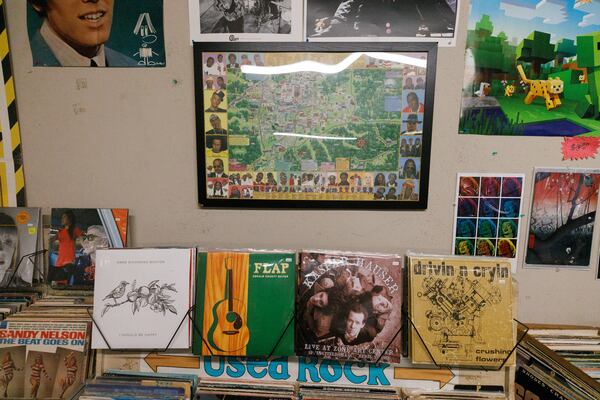 A Wax ’n’ Facts map sits above vinyls from Atlanta musicians, including Anne Richmond Boston's "I Should Be Happy" (on the left). (Estela Muñoz/AJC)