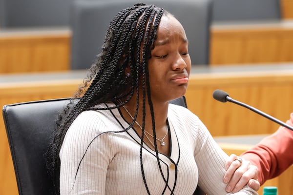 Tiffani McLean-Camp, who was under the care of the Georgia Division of Family & Children Services as a youth, sheds a tear as she testifies during the third hearing into the state's foster care system at Georgia State University School of Law in 2023. (Natrice Miller/AJC)
