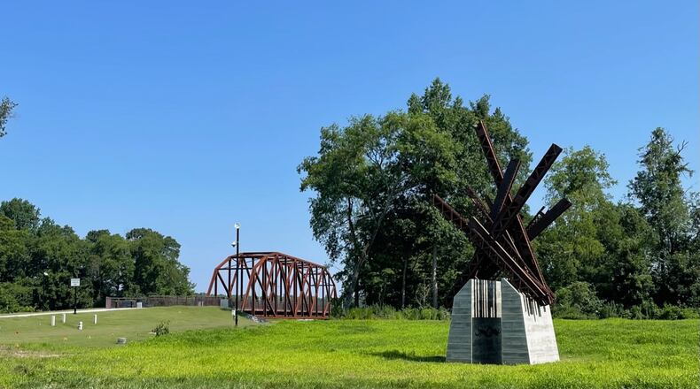 Duluth will begin work soon to create two parking lots at the Rogers Bridge Park Trailhead. Shown here the newly replaced bridge and sculpture created from steel from the old bridge. (Photo by Karen Huppertz for the AJC)
