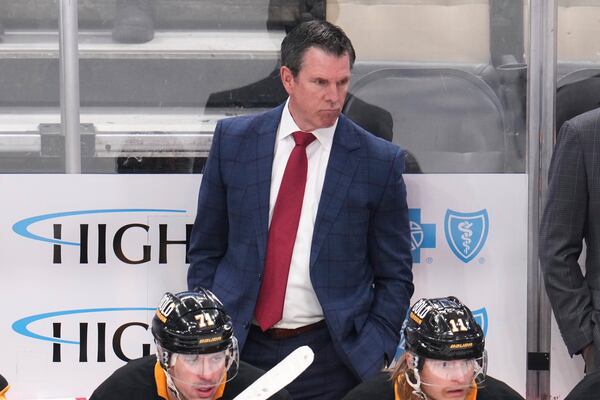 Pittsburgh Penguins head coach Mike Sullivan stands behind his bench during the third period of an NHL hockey game against the Boston Bruins in Pittsburgh, Sunday, April 13, 2025. (AP Photo/Gene J. Puskar)