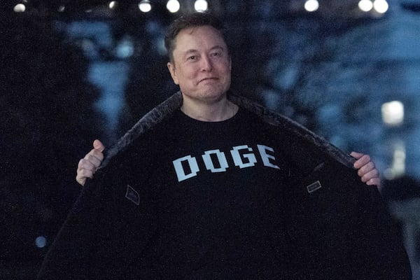 FILE - Elon Musk flashes his T-shirt that reads "DOGE" to the media as he walks on the South Lawn of the White House, in Washington, March 9, 2025. (AP Photo/Jose Luis Magana, File)