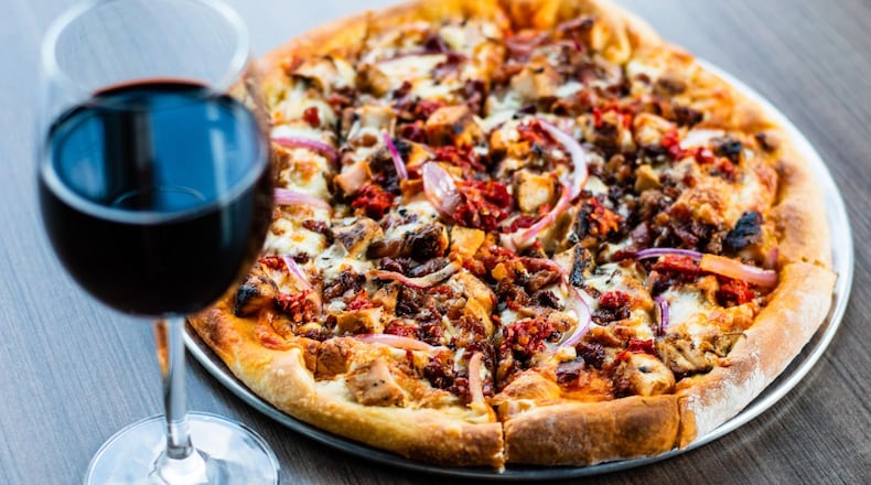 Firepit Pizza Tavern in Grant Park serves grilled chicken pizza with a white sauce base. Beverages include beer, cocktails and some 20 wines by the glass. CONTRIBUTED BY HENRI HOLLIS