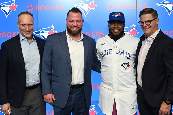 Toronto Blue Jays president and CEO Mark Shapiro poses with, from left, Blue Jays manager John Schneider, Toronto Blue Jays first baseman Vladimir Guerrero Jr. and team general manager Ross Atkins at a press conference announcing Guerrero's 14 year, $500 million dollar contract extension in Toronto on Monday April 14, 2025. (Jon Blacker/The Canadian Press via AP)