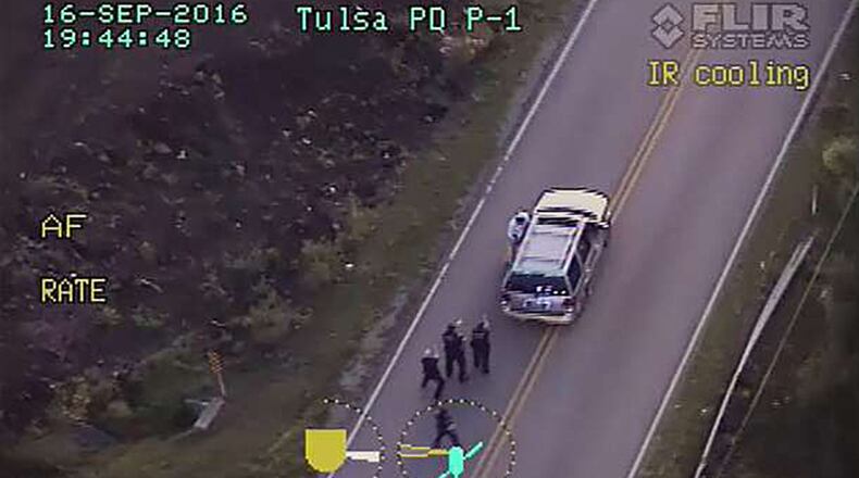 In this image made from a Friday, Sept. 16, 2016 police video, Terence Crutcher, top, is pursued by police officers as he walk to an SUV in Tulsa, Okla. Crutcher was pronounced dead after he was shot by the officer, police said.