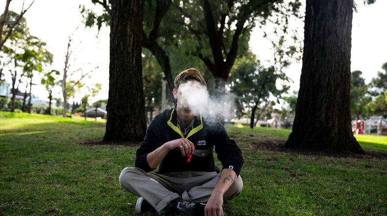 High school senior Bennett Kelly vapes a Puff Bar, one of a number of disposable e-cigarette brands that remain available, in Costa Mesa, Calif., on Thursday, Jan. 30, 2020. Food and Drug Administration police allows mint, dessert and fruit flavors to continue to be sold in disposable e-cigarettes, prompting many teens to switch from Juul to those devices. (Jenna Schoenefeld/The New York Times)