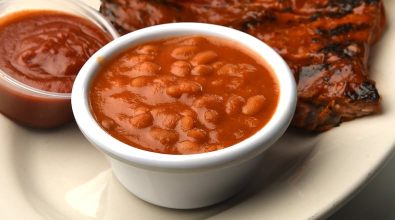 Fat Matt's Rib Shack's “Rum” Baked Beans, pictured with ribs, sauce and bread.
(CHRIS HUNT FOR THE ATLANTA JOURNAL-CONSTITUTION)