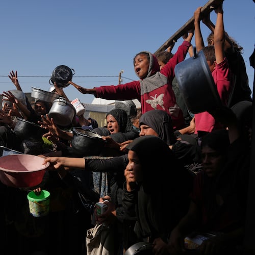 Palestinians wait to get donated sugar and rice at a community kitchen in Khan Younis, southern Gaza Strip, Friday, Oct. 31, 2025. (AP Photo/Abdel Kareem Hana)