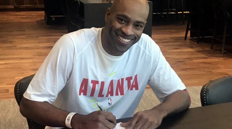 Vince Carter signs his one-year contract with the Hawks Friday.