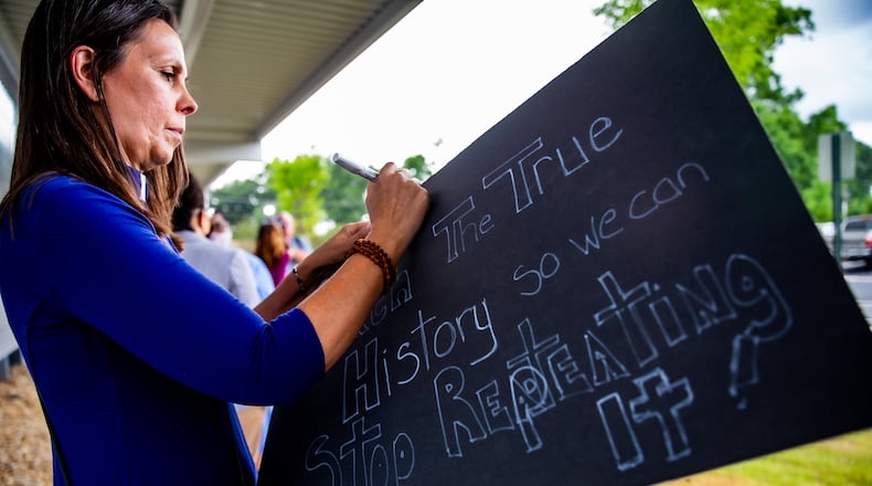 Rev, Deborah Bennett of the Unitarian Universalist Congregation in Marietta finish her sign while holding her place in line to speak before a Cobb County of Education board meeting begins. Teachers, parents and local residents gather to voice their opinions on critical race theory and what Cobb County teaching and the reviews initiated by the school board Thursday, June 10, 2021. (Jenni Girtman for The Atlanta Journal Constitution)