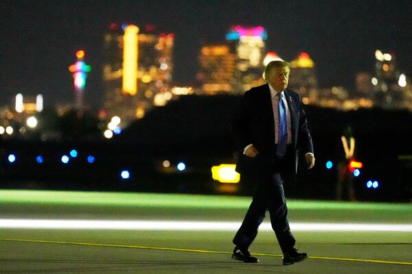 With downtown Calgary in the background, President Donald Trump walks from Marine One to board Air Force One at Calgary International Airport, Monday, June 16, 2025, in Calgary, Canada, on his way back to Washington. (AP Photo/Mark Schiefelbein)