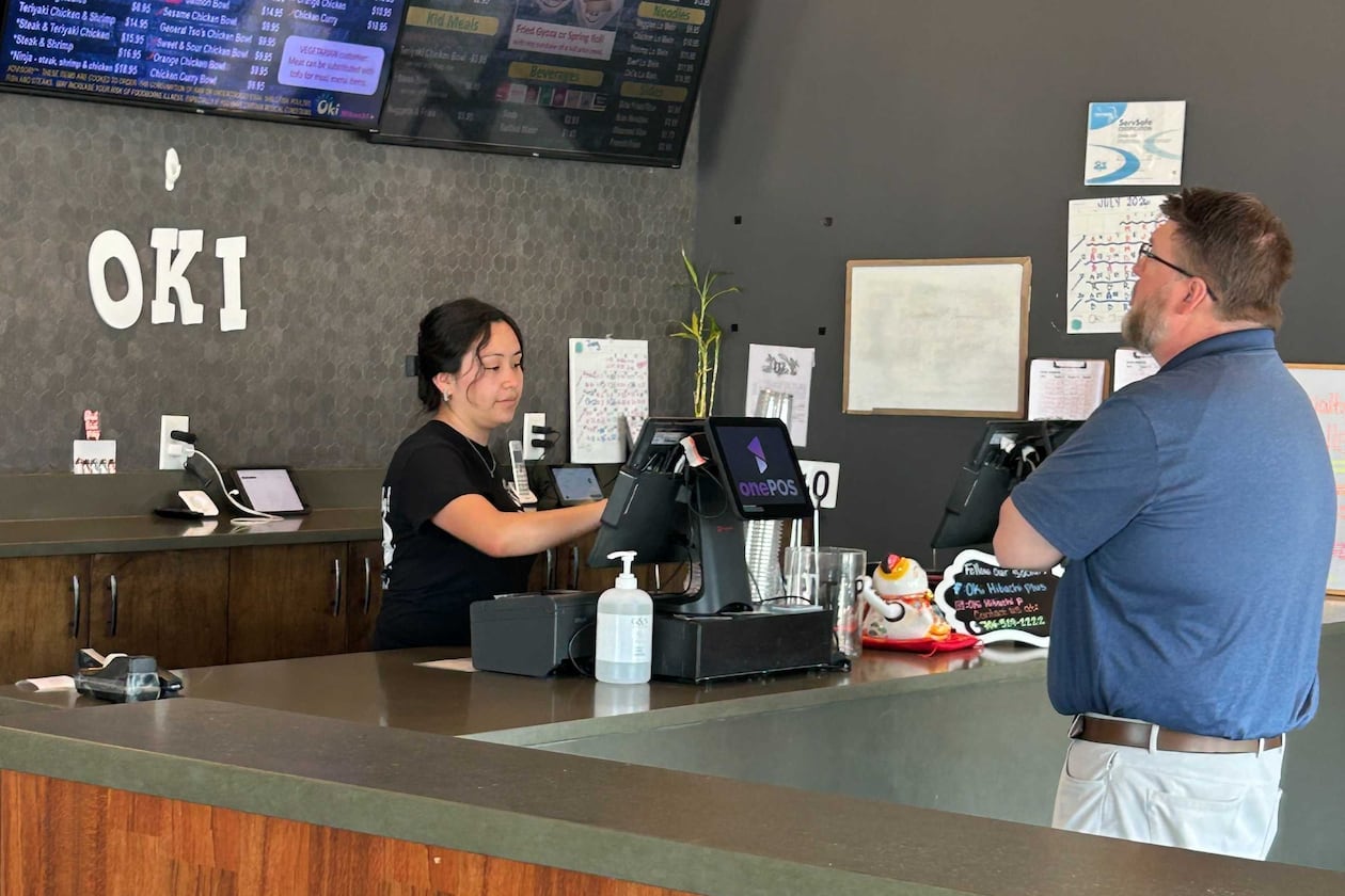 Karen Ajanel serves a customer at her job. Ajanel, a Dalton State College student, credits the Orange Duffel Bag Initiative, credits the program with helping in her academic journey. (Courtesy)