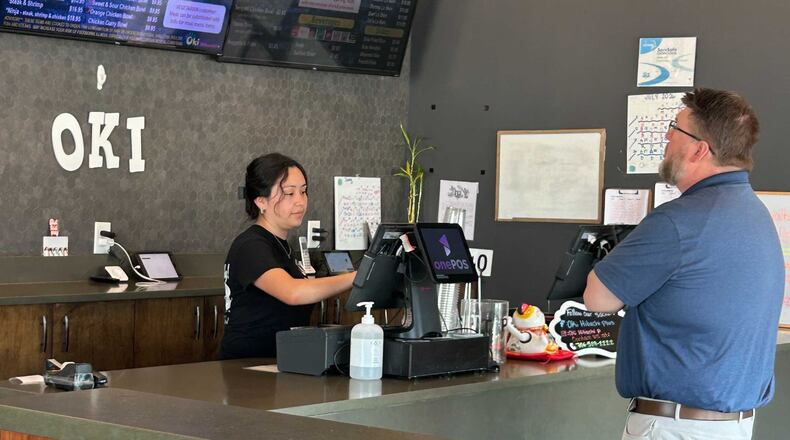 Karen Ajanel serves a customer at her job. Ajanel, a Dalton State College student, credits the Orange Duffel Bag Initiative, credits the program with helping in her academic journey. (Courtesy)