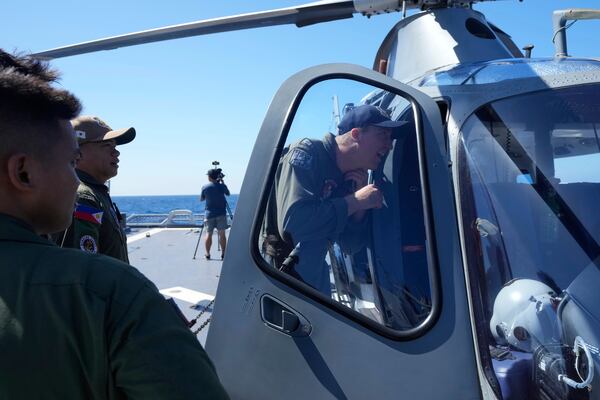 US Navy Lt. Alexander Hovarth from California check a Philippine helicopter on board the Philippine Navy Ship BRP Jose Rizal during the Philippines Japan United States Multilateral Maritime Cooperative Activity off a disputed South China Sea shoal on Friday, March 28, 2025. (AP Photo/Aaron Favila)