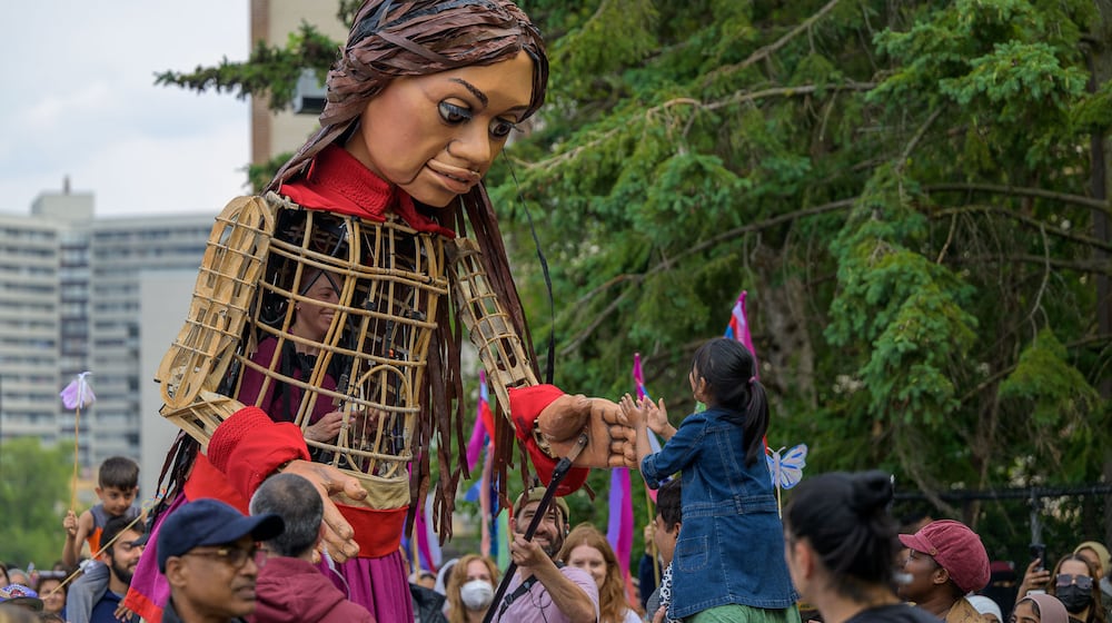 Little Amal greets a child at the 2023 Luminato Festival Toronto. The giant-sized puppet will visit Atlanta as part of the art happening, "Amal Walks Across America," created by playwright and director Amir Nizar Zuabi.
(Courtesy of Taku Kumabe)