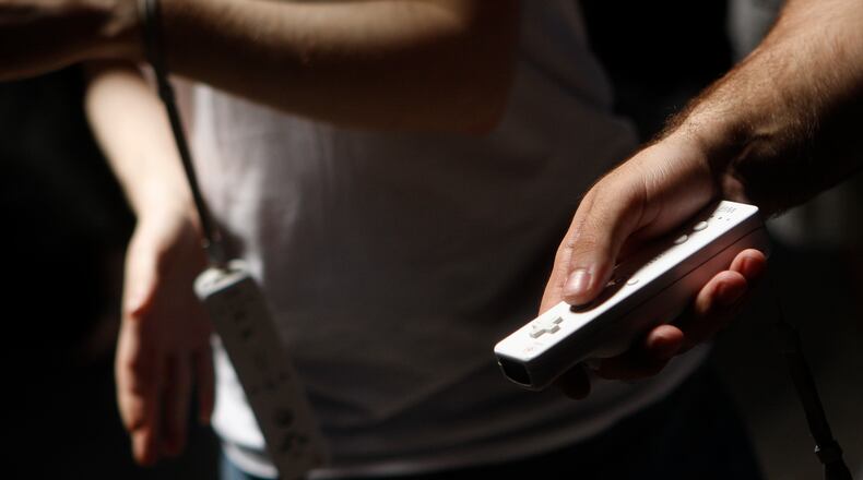 Gamers hold Wii controllers. (Photo by Joshua Lott/Getty Images)