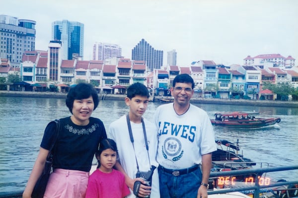 AJC photojournalist Arvin Temkar (center) poses for a photo with his mother, Daisy Perez (left), sister Tara Temkar (second from left) and father Prakash Temkar in a family photo taken in Singapore in 2000. (Courtesy of Arvin Temkar)
