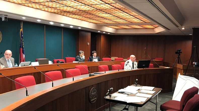 Decatur City Attorney Bryan Downs, at the podium, appeared before the Georgia Immigration Enforcement Review Board in May 2018 with Police Chief Mike Booker, seated to his right, and defended the city against a complaint filed by Lt. Gov. Casey Cagle.