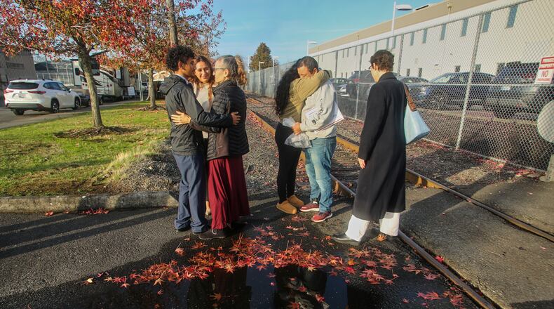 Immigrants from Portland, including Victor Cruz, center right, in the gray hooded sweatshirt, embrace family members after being released on bond in Tacoma, Wash., Friday, Nov. 7, 2025. (AP Photo/Cedar Attanasio)