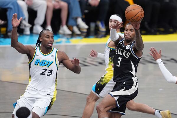 Milwaukee Bucks' Kevin Porter Jr. (3) passes as Indiana Pacers' Aaron Nesmith (23) watches during the first half of a first-round NBA basketball playoff game, Saturday, April 19, 2025, in Indianapolis. (AP Photo/Michael Conroy)