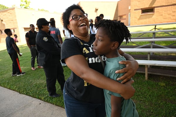 Keora Willis (center) reacts as she reunites with her son, Jaquez Willis, 9, after his tour of the Athens-Clarke County Correctional Institution. Asked what the tour made him want to do, Jaquez answered, “Being good to my mom.” (Hyosub Shin/AJC)