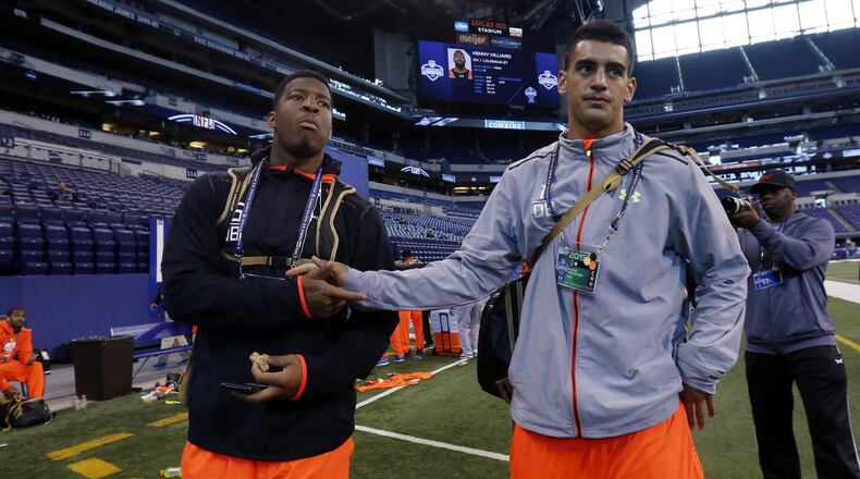 Florida State quarterback Jameis Winston, left, walks with Oregon quarterback Marcus Mariota after participating at the NFL football scouting combine in Indianapolis, Saturday, Feb. 21, 2015. (AP Photo/Julio Cortez)