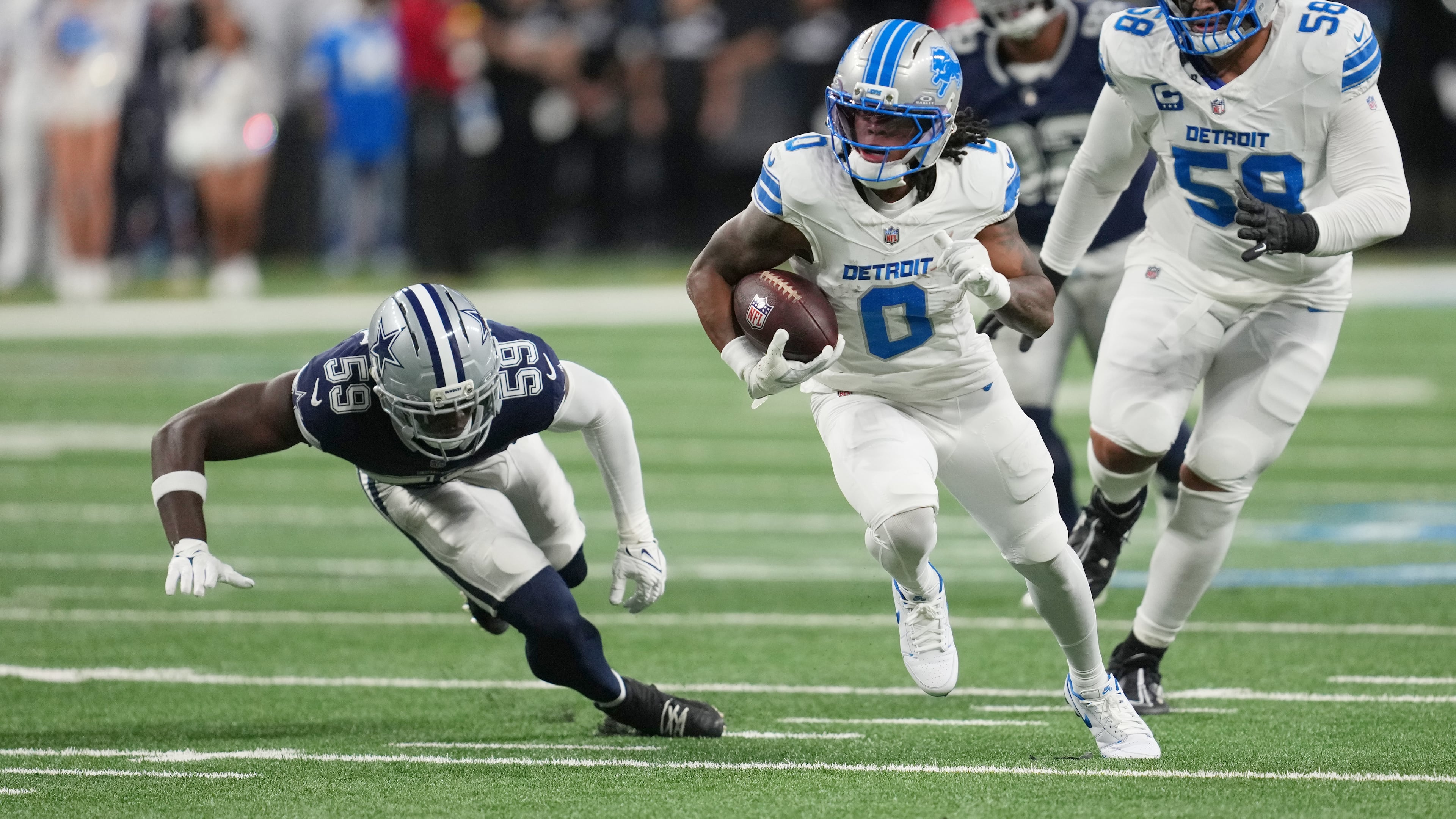 Detroit Lions running back Jahmyr Gibbs (0) runs the ball as Dallas Cowboys linebacker Jr. Kenneth Murray (59) tries to stop him during the first half of an NFL football game Thursday, Dec. 4, 2025, in Detroit. (AP Photo/Paul Sancya)