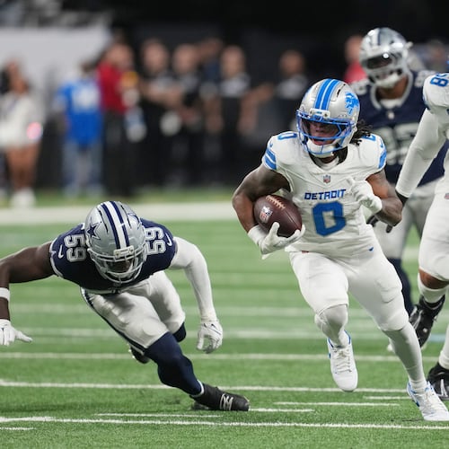 Detroit Lions running back Jahmyr Gibbs (0) runs the ball as Dallas Cowboys linebacker Jr. Kenneth Murray (59) tries to stop him during the first half of an NFL football game Thursday, Dec. 4, 2025, in Detroit. (AP Photo/Paul Sancya)