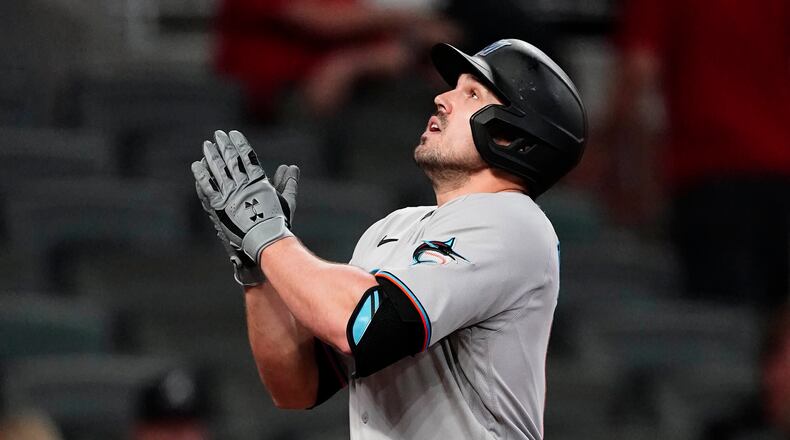 Miami Marlins' Adam Duvall gestures as he crosses the plate after hitting a three-run home run during the seventh inning of the team's baseball game against the Atlanta Braves on Tuesday, April 13, 2021, in Atlanta. (AP Photo/John Bazemore)