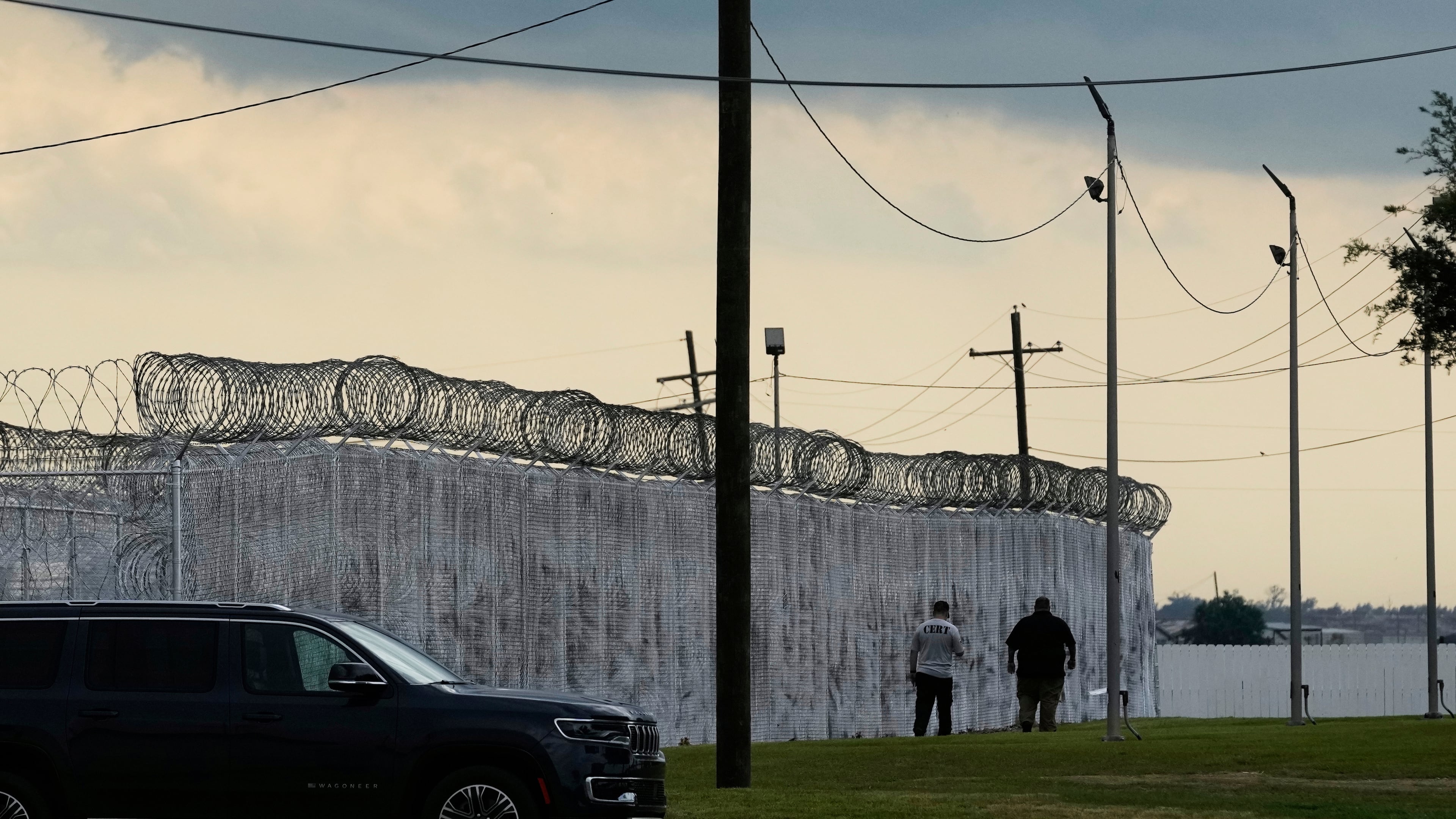 FILE - Security walk outside "Camp 57," a facility to house immigration detainees at the Louisiana State Penitentiary in Angola, La., on Sept. 3, 2025. (AP Photo/Gerald Herbert, File)