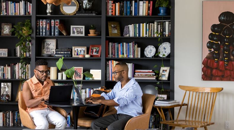 Everett Long and Fred Smith work in the library of their Midtown home. (Tomas Espinoza for the AJC)