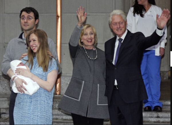 Former President Bill Clinton, right, and former Secretary of State Hillary Rodham Clinton, second from right, wave to the media as Marc Mezvinsky and Chelsea Clinton pose for photographers with their newborn baby, Charlotte, after the family leaves Manhattan's Lenox Hill hospital in New York, Monday, Sept. 29, 2014. (AP Photo/William Regan)
