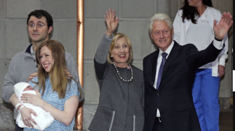 Former President Bill Clinton, right, and former Secretary of State Hillary Rodham Clinton, second from right, wave to the media as Marc Mezvinsky and Chelsea Clinton pose for photographers with their newborn baby, Charlotte, after the family leaves Manhattan's Lenox Hill hospital in New York, Monday, Sept. 29, 2014. (AP Photo/William Regan)