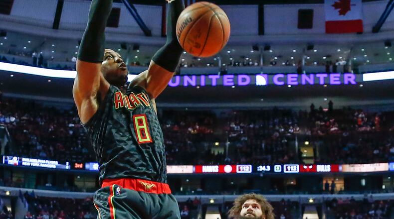 Atlanta Hawks center Dwight Howard, left, dunks the ball against Chicago Bulls center Robin Lopez, center, during the second half of an NBA basketball game, Wednesday, Jan. 25, 2017, in Chicago. The Hawks won 119-114. (AP Photo/Kamil Krzaczynski)