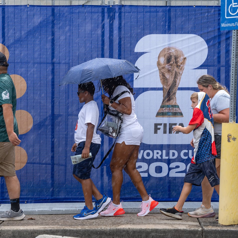 Soccer fans walk in the rain to Atlanta Stadium for the South Africa vs. Czechia match on Thursday. (Ben Hendren for the AJC)