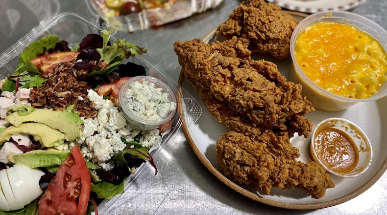 This takeout dinner from Joy Cafe includes: Cobb salad; fried chicken; salmon and lentil salad; and green-tomato tarts in the background. Wendell Brock for The Atlanta Journal-Constitution