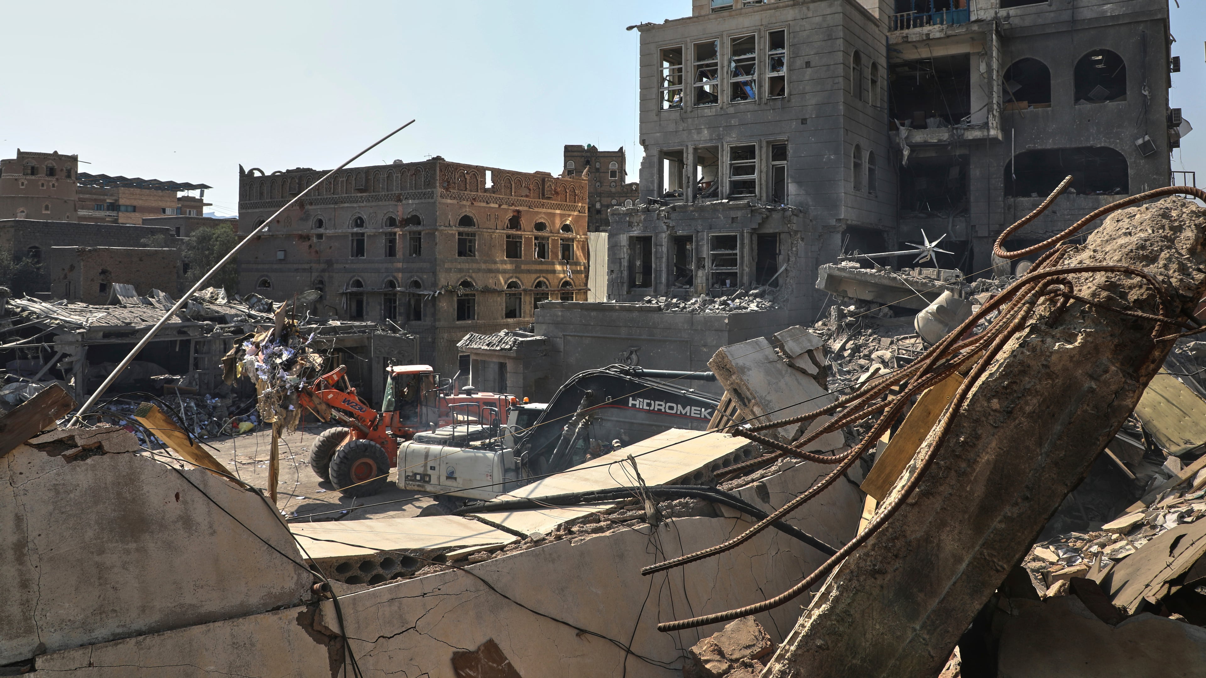 FILE - Workers use heavy machinery to clear rubble from buildings destroyed in an Israeli airstrike in Sanaa, Yemen, on Sept. 13, 2025. (AP Photo/Osamah Abdulrahman, File)