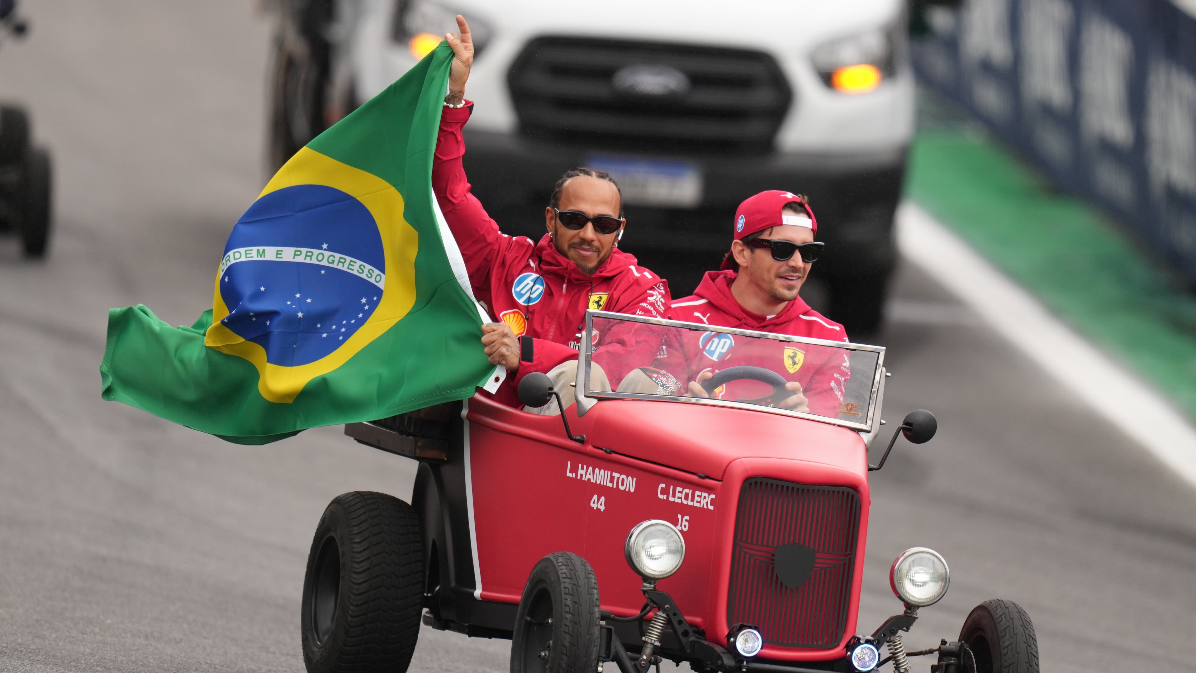 Ferrari driver Lewis Hamilton of Britain, left, and Ferrari driver Charles Leclerc of Monaco wave to the crowd during the opening parade at the Brazilian Formula One Grand Prix at the Interlagos race track in Sao Paulo, Sunday, Nov. 9, 2025. (AP Photo/Andre Penner)