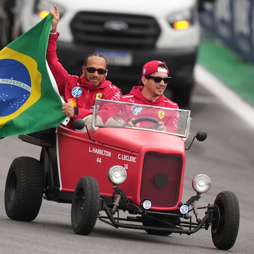 Ferrari driver Lewis Hamilton of Britain, left, and Ferrari driver Charles Leclerc of Monaco wave to the crowd during the opening parade at the Brazilian Formula One Grand Prix at the Interlagos race track in Sao Paulo, Sunday, Nov. 9, 2025. (AP Photo/Andre Penner)
