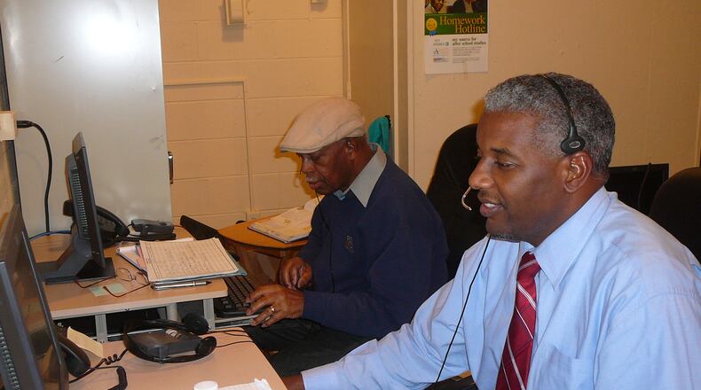 Glenn Randall (l) and Kevin Wright answer calls at the Homework Hotline, a free community service provided by the Atlanta Public School system. The 5-member team fields questions from students around the country.