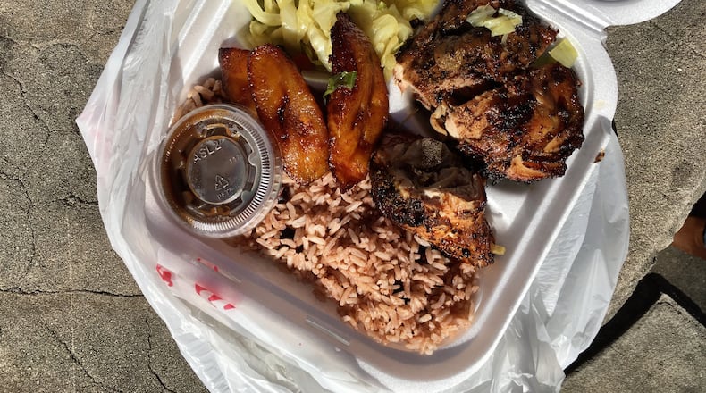 A plate of jerk chicken served with rice and peas, steamed cabbage, and ripe plantains at Irie Mon Cafe. PHOTO CREDIT: Wyatt Williams