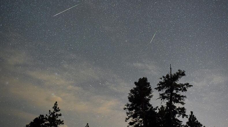 SPRING MOUNTAINS NATIONAL RECREATION AREA, NV - AUGUST 13: A pair of Perseid meteors streak across the sky above desert pine trees on August 13, 2015 in the Spring Mountains National Recreation Area, Nevada. The annual display, known as the Perseid shower because the meteors appear to radiate from the constellation Perseus in the northeastern sky, is a result of Earth's orbit passing through debris from the comet Swift-Tuttle. (Photo by Ethan Miller/Getty Images)
