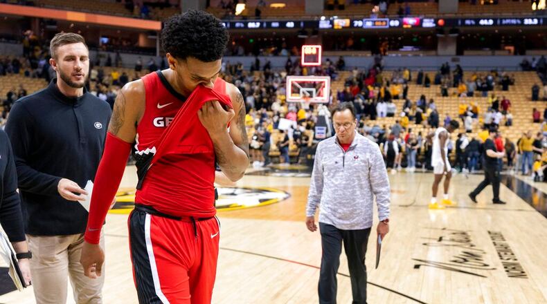 Georgia's Braelen Bridges wipes his face as he walks off the court and coach Tom Crean (right) follows after losing 79-69 to Missouri in an NCAA college basketball game Saturday, March 5, 2022, in Columbia, Mo.  (AP Photo/L.G. Patterson)