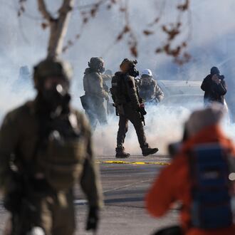 Federal immigration officers deploy tear gas at observers after a shooting Saturday, Jan. 24, 2026, in Minneapolis. (AP Photo/Abbie Parr)
