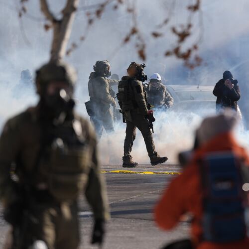 Federal immigration officers deploy tear gas at observers after a shooting Saturday, Jan. 24, 2026, in Minneapolis. (AP Photo/Abbie Parr)